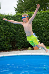 boy is jumping in the pool