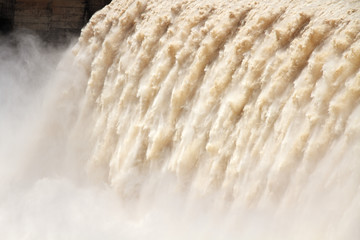 Flowing water from the open sluice gates of a dam