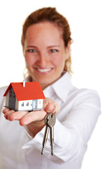 Immobilienmaklerin überreicht Hausschlüssel