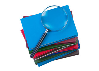 Stack of books with magnifying glass isolate on white background
