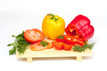 Pepper, tomato with dill and parsley on the wood desk isolated