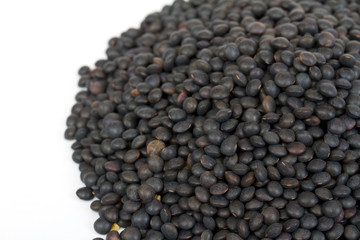 Heap of black lentil isolated on white