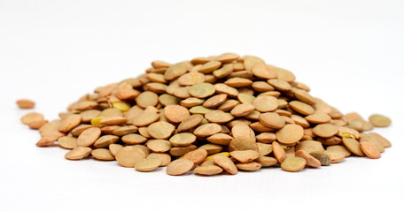 Pile of green lentils from low perspective isolated on white.