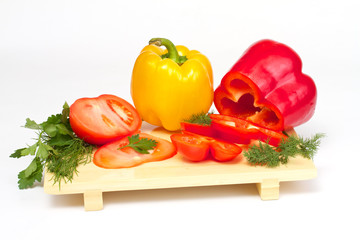 Pepper, tomato with dill and parsley on the wood desk isolated