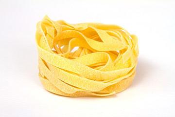 heap of raw dry nest pasta over white background