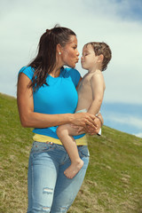 Pretty young hispanic woman kissing a baby boy