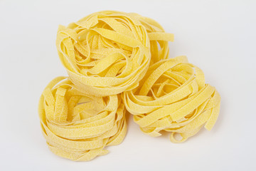 heap of raw dry nest pasta over white background