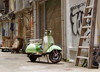 Classic green old scooter in back alley of downtown Hong Kong © Oksana Perkins