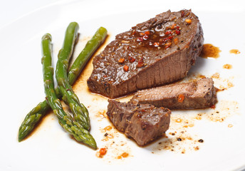 Grilled steak with Green asparagus on white background