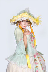 Woman in a theatrical outfit using her fingers as a pretend gun