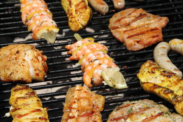 Grillen: diverses Grillfleisch und Scampi-Spieß auf dem Grill