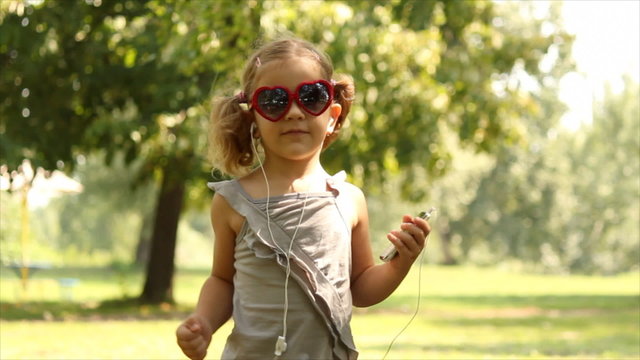 little girl listening music and dancing