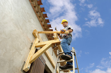 construction d'un auvent par un ouvrier menuisier