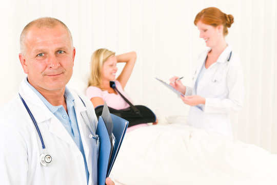 Medical doctors with hospital patient lying bed