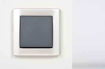 light switch on the wall with grey button on silver frame