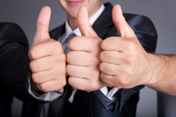 Three young business man a thumb up sign