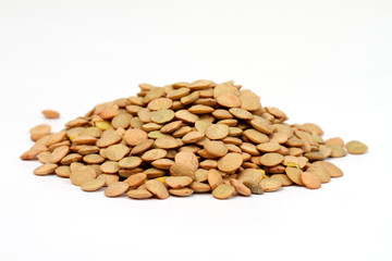 Pile of green lentils from low perspective isolated on white.