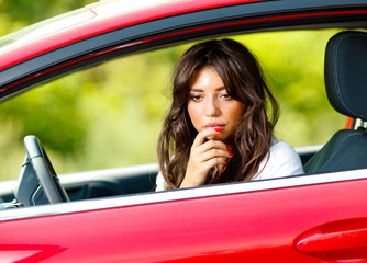 Fototapeta na wymiar Young pretty woman in the red car