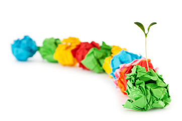 Paper recycling concept with seedlings on white