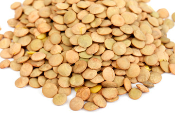 Pile of green lentils from low perspective isolated on white.