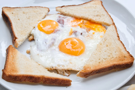 fried egg with bacon and toasts