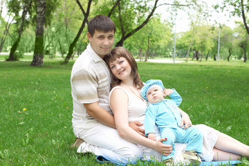 Naklejka na ściany i meble Young family together in the park