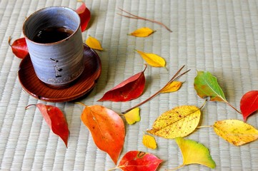 畳の上の落ち葉と湯呑み