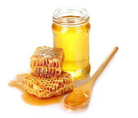 Beautiful combs, spoon and honey in jar isolated on white