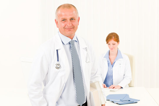 Medical team senior male doctor young woman