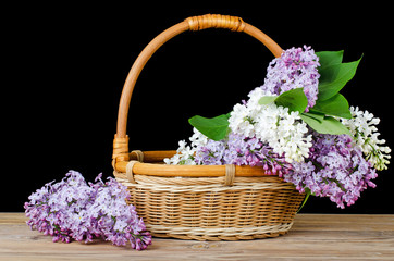 Fototapeta na wymiar Lilac bouquet in a wattled basket