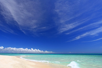真っ白な砂浜に打ち寄せる波と真っ青な空