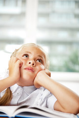 Portrait of a young girl in school at the desk.