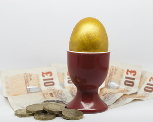 Golden Egg in an egg cup with money