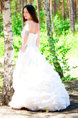 Obraz na płótnie Canvas bride with dark-brown hair posing in forest