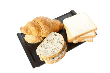 bread, sesame, white bread and croissant on black tray.