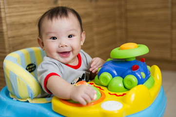 Obraz premium Chinese Asian toddler sitting in walker chair