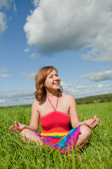 girl meditating on grass and smiling