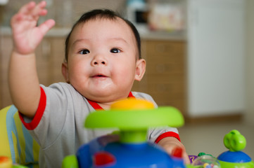 Chinese Asian toddler sitting in walker chair