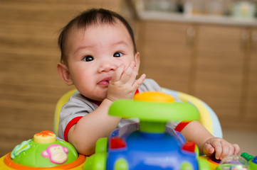 Chinese Asian toddler sitting in walker chair