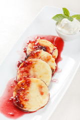 Cheese pancakes with cherry sauce
