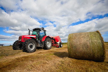 tractor collecting haystack in the field