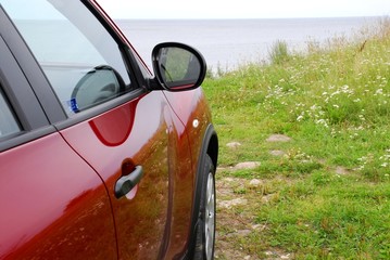 Red car on a sea coast