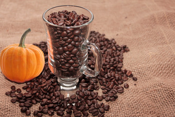 Coffee of autumn on burlap with pumpkin.
