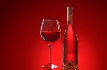 wine bottle and glasses on red background
