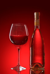 wine bottle and glasses on red background