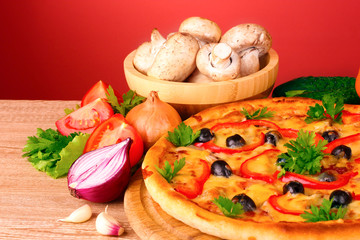 pizza and vegetables on red background