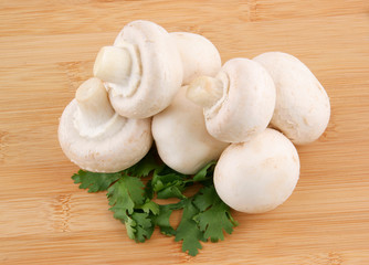 Fresh mushrooms and parsley on wooden background