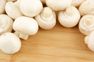 Fototapeta na wymiar Fresh mushrooms champignon on wooden background