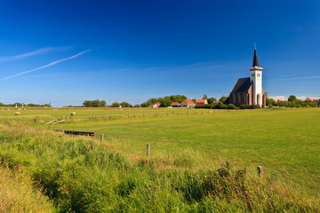 Fototapeta na wymiar Church with grassland on a sunny day