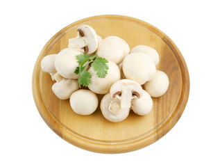Fresh mushrooms and parsley on wooden cutting board isolated